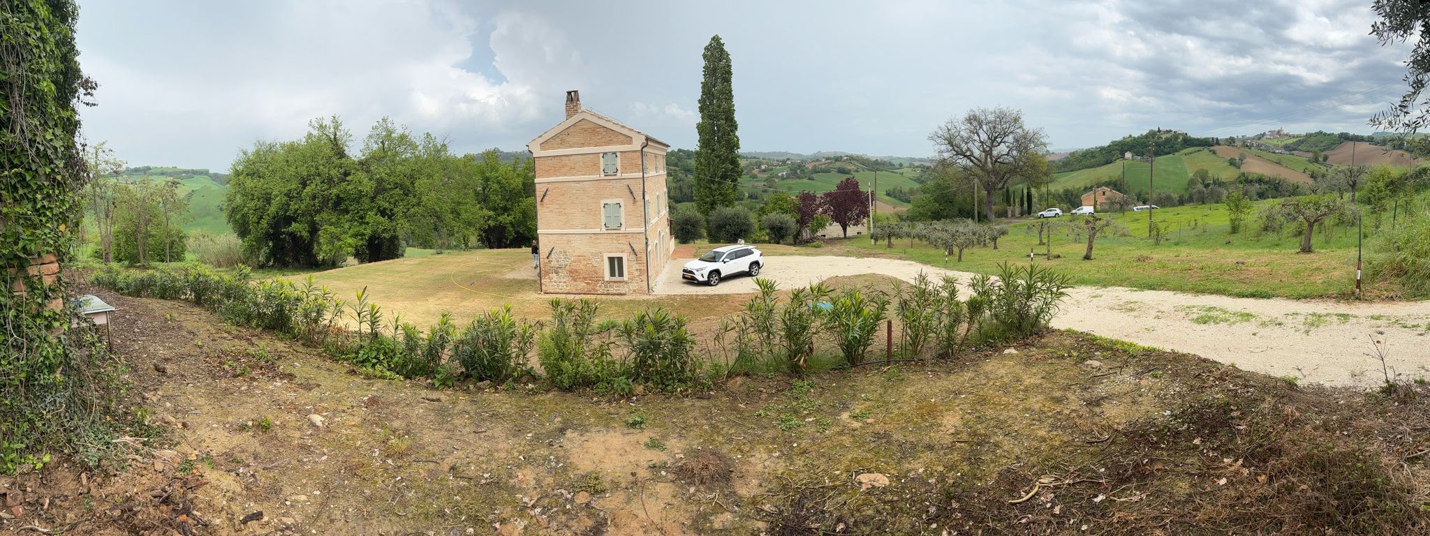 The house across the garden, with the hills of the Marche behind