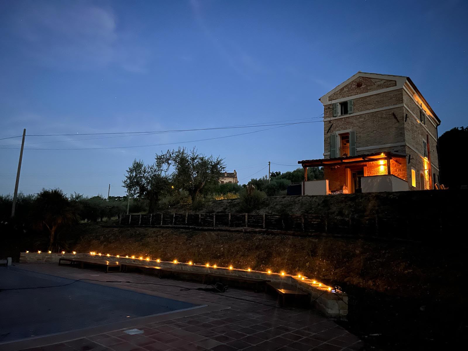 The house at dusk, with candles along the pool terrace